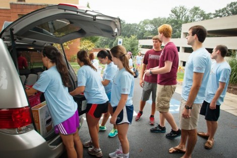 Orientation volunteers help families and students move their belongings into Kamine Hall.