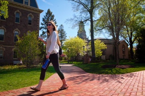 A student walks along the brick pathway near Pardee Hall and Colton Chapel.
