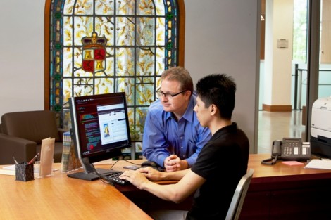 Eric Luhrs, left, digital initiatives librarian, and Miguel Haruki Yamaguchi '11 work in the rare books reading room on MetaDB, a software program that Luhrs created to allow scholars and librarians to collaborate on the creation of metadata. 