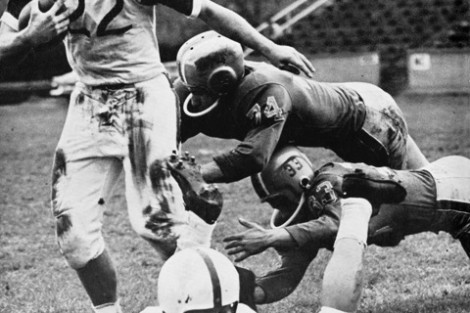 A running back eludes would-be-tacklers in 1960.