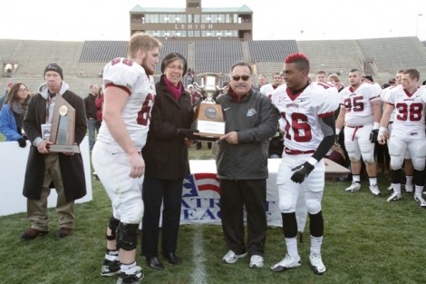 Offensive lineman Brad Bormann ’14, l-r, head coach Frank Tavani, and defensive back Randall Logan ’14 are presented with the Patriot League Championship trophy.