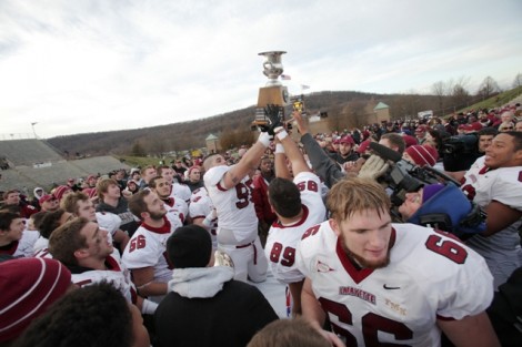 Players take turns holding the Patriot League Championship trophy.