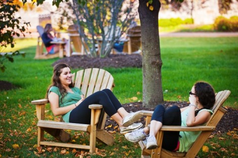 Laura Trocchia '17, left, and Corinna Anderson '17 relax on the Adirondack chairs on the Quad.  