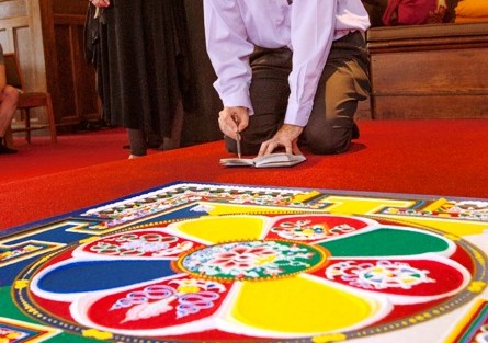 Chris Phillips, assistant professor of English, sketches the mandala.