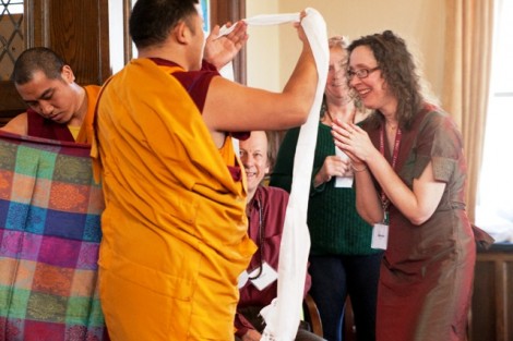 A monk presents a prayer scarf to Jane Marie Duh, identity management systems architect in ITS and Buddhist adviser.