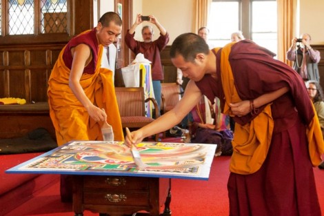 The monks begin dismantling the mandala. 