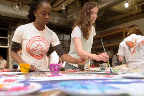 Andrea Hayford '15, left, and Caitlin Young '15 paint on the canvas.
