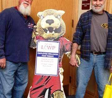 Bill Dew, left, groundskeeper in plant operations, and Charlie Rickenbach, clerk at the mail center pose with the Wellness Fair leopard.