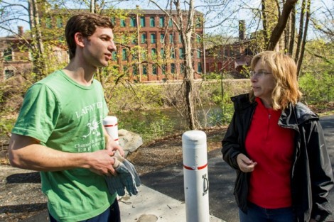Seth Kyler ’15 gets ready for work while speaking with Monica Seligman, coordinator and volunteer for Friends of the Karl Stirner Arts Trail.
