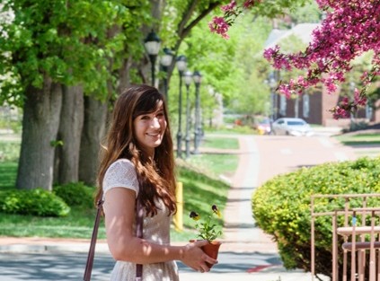 A student carries flowers past Van Wickle Hall.