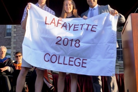 Alex Karapetian ’04, president of the Alumni Association, presents the Class of 2018 banner to Matt  Dicker, son of Jim Dicker '85 and Mandy Shane Dicker '84, and Lucy Linville, daughter of Jud Linville '79 and Cindy Oaks Linville '80.