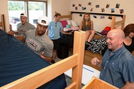 Members of the football help new students set up their rooms.