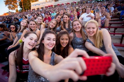 Cheerleaders and dance team members take a selfie together.