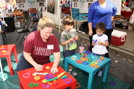 Professor Lauren Myers plays with local children at the Lafayette Kids Lab tent.  Photo by Clay Wegrzynowicz ’18