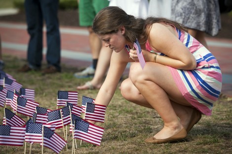 A student places a flag on the Quad.