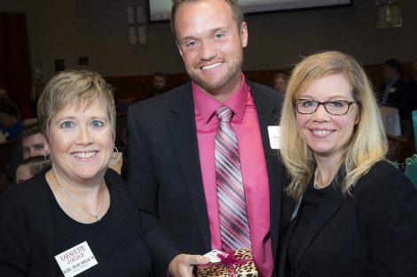 Rachel Nelson Moeller ’88, executive director of Alumni Relations, and Janine Casey, associate director, present the Huhn Correspondent Award to Paul Sommers '09.