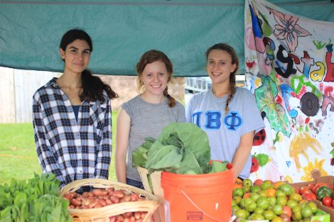 3 students stand by vegetables that will be distributed to Easton residents.