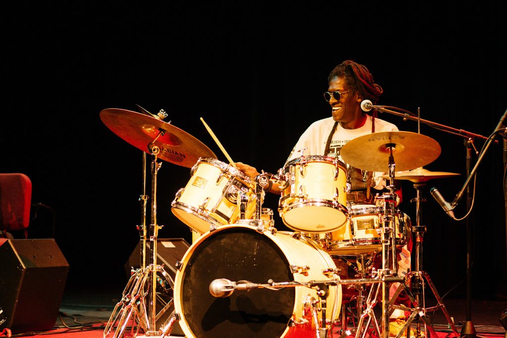 Cheikh Lo plays the drums.