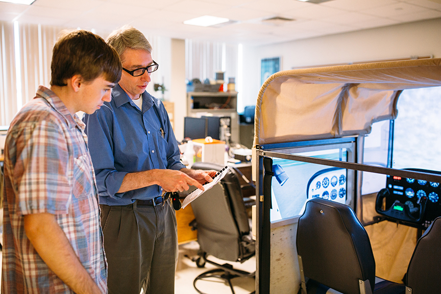 Professor Jon Wallace and a student look at a document together in the lab.