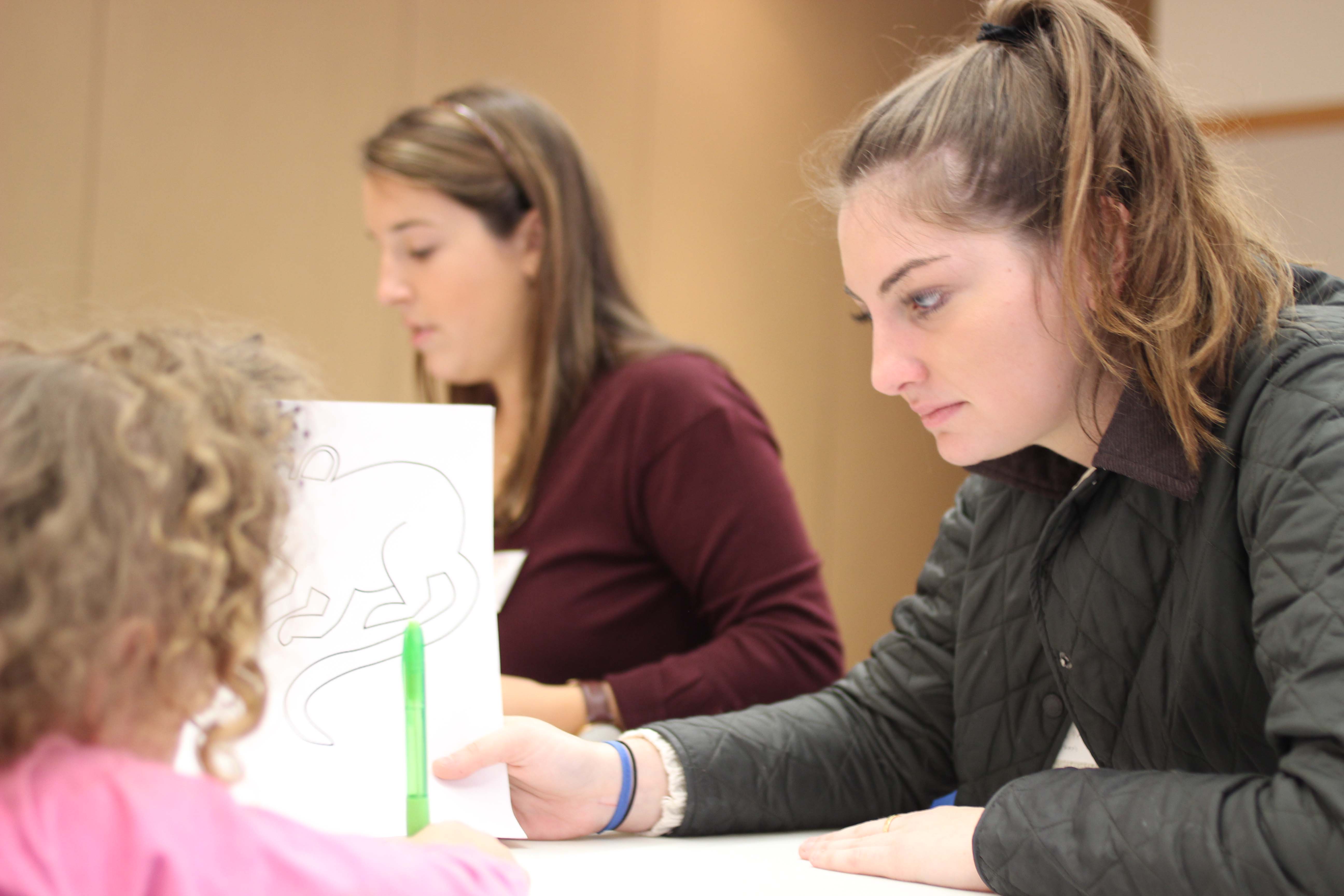 A Lafayette woman student helps a young girl with her drawing.