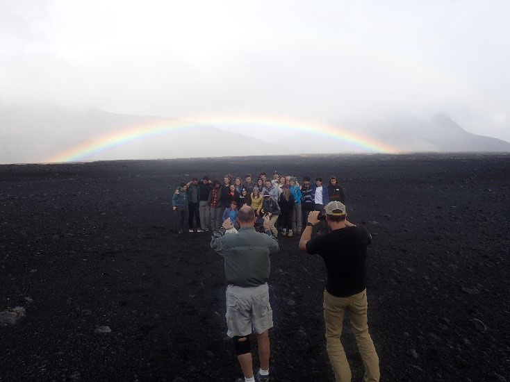 Students stand with a rainbow in the background at Askja Caldera in Iceland