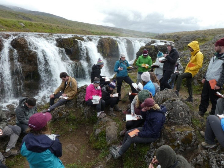 Students have a discussion by the Kolugljúfur waterfall in northern Iceland.