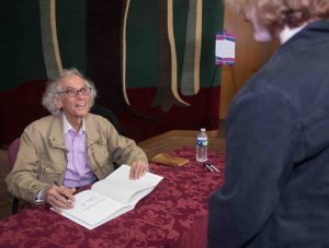World-famous environmental artist Christo signs a book after giving the 2018 Grossman Visiting Artist lecture.