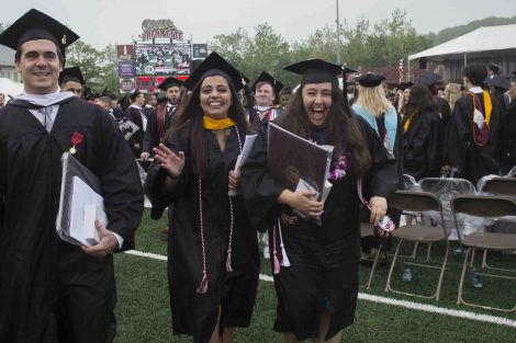 Three grads smile after Commencement.