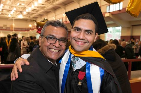 A father and son pose for a photograph after Commencement.