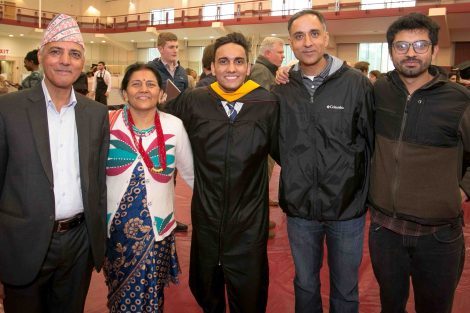 A family of five poses for a photograph after Commencement.