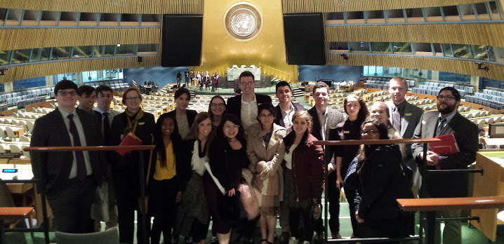Students sit inside the United Nations assembly room.