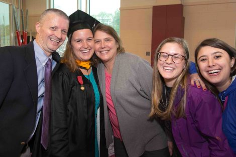 A family of five smiles for a photo after Commencement.