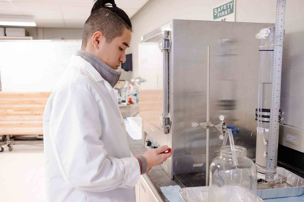 A student works in the lab on the biofilm project.