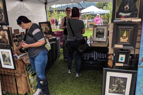A vendor with framed art talks to a customer at the Riverside Festival of the Arts in Easton.