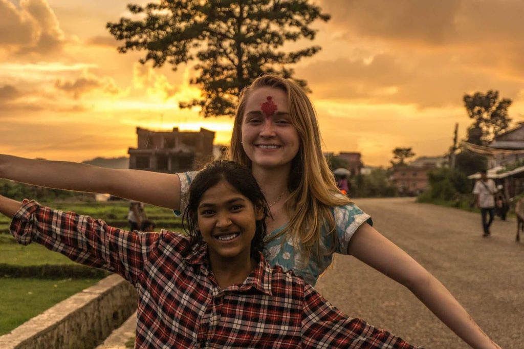 Thea Dekker and a girl smile and pose for a photo during sunset