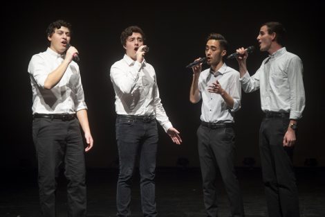 Student a cappella singers perform on stage.