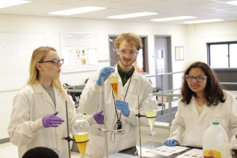 Students hold up various biofuels.