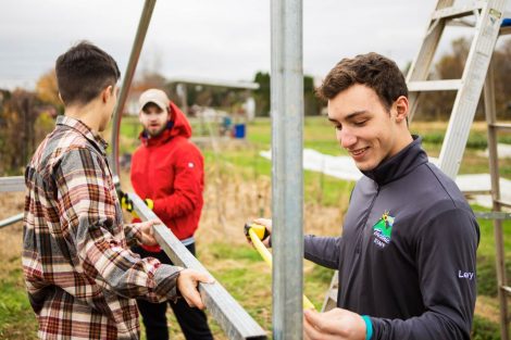 Members of Phi Psi fraternity help with the building of a hoop house, a 22-by-21-foot structure that will help LaFarm extend its growing season earlier in spring and later in fall.