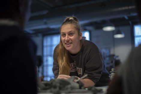 A Lafayette student smiles as she helps work with clay.