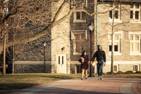 two students walk in front of hogg hall
