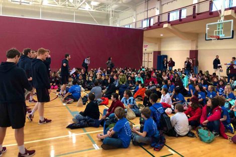 Lacrosse players volunteer their time at School Day Game Day which brought nearly 700 fifth graders to watch a women's basketball game.