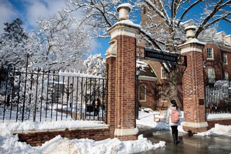 A student walks through a gateway to Lafayette College after snowfall.