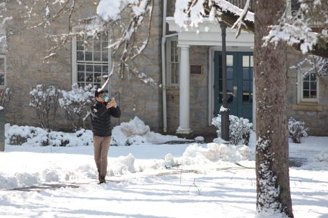 A student takes a photo with his smartphone outside the Simon Center after snowfall on Lafayette's campus.