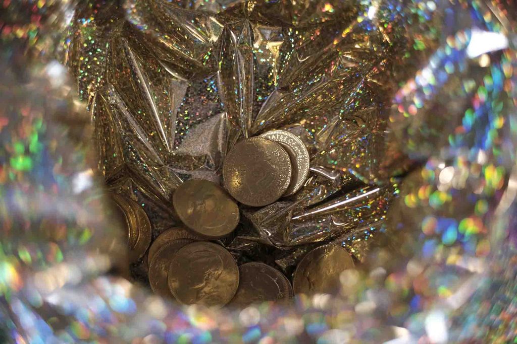 A close up of the gold coins in a pot.