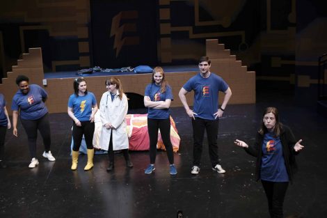 The cast and director of Miss Electricity stand on stage