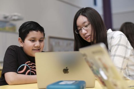 Lafayette student shows an elementary student one of her code projects.