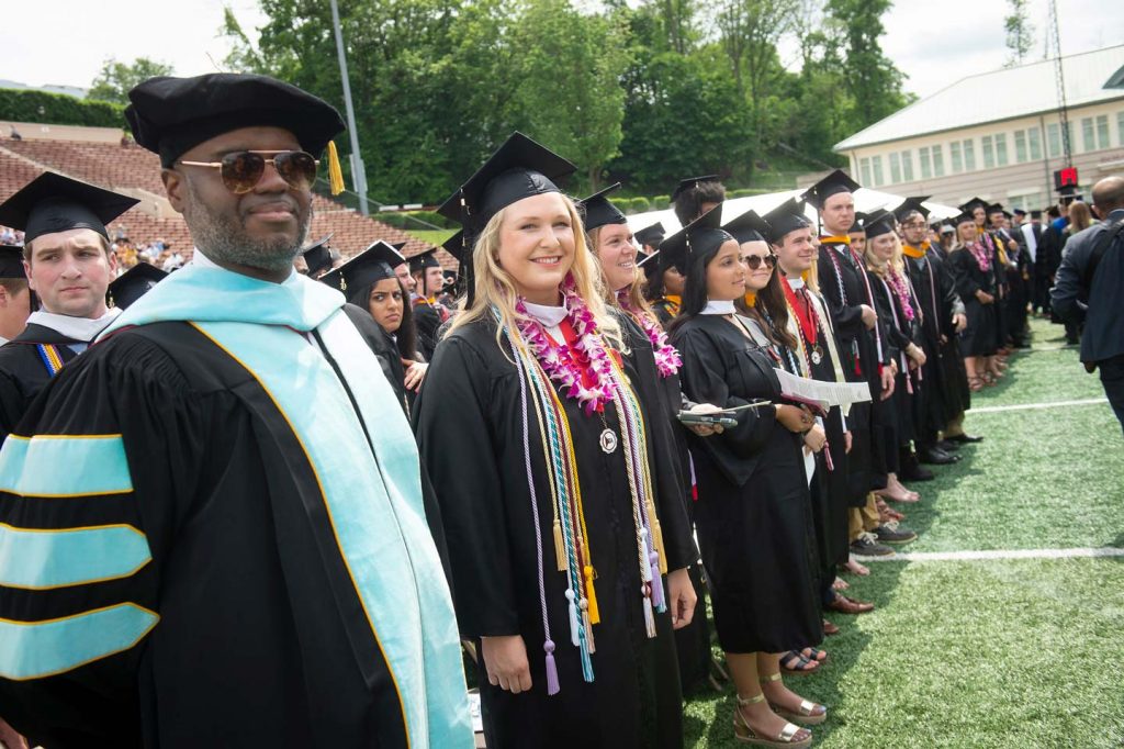 Reeve Lanigan '19 and Dean of Students Chris Hunt stand with others during Commencement.