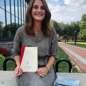Professor Jennifer Gilmore holds Collected Poems, 1947-1980 by Allen Ginsberg while sitting outside Skillman Library.