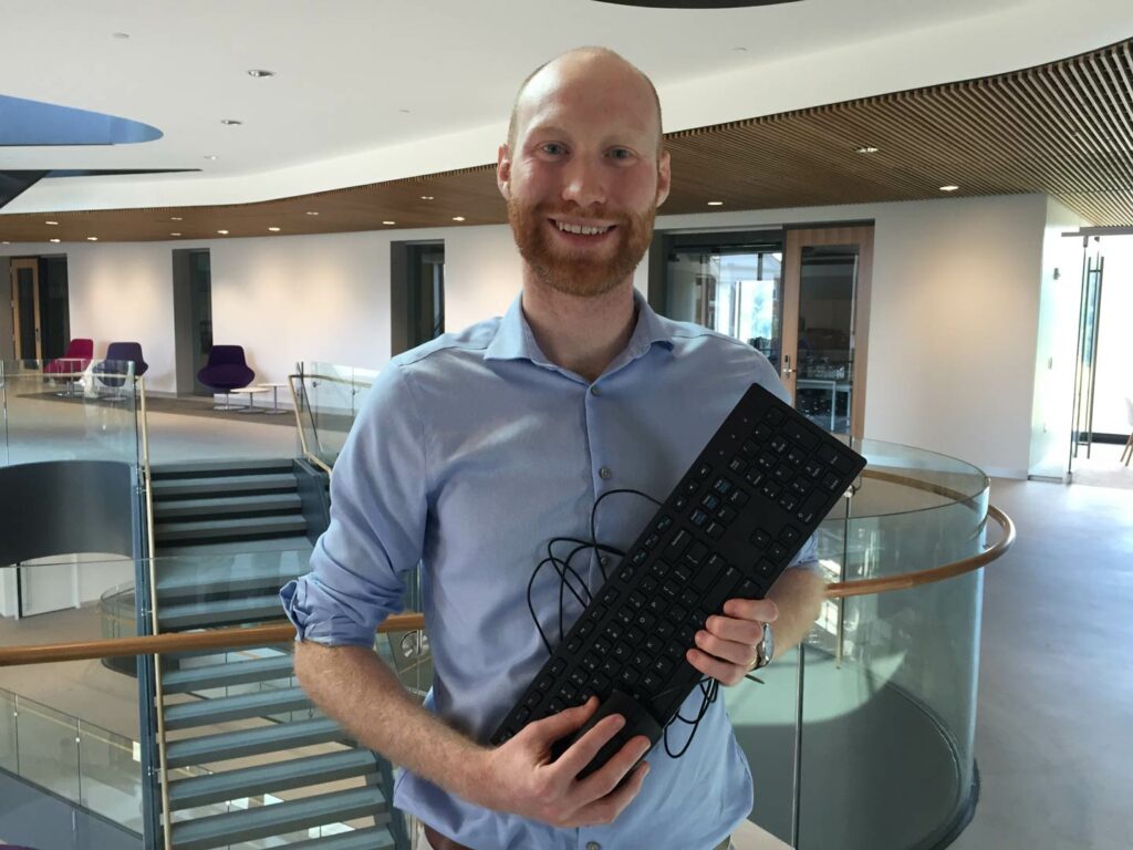 Professor Justin Smith holds a computer keyboard.