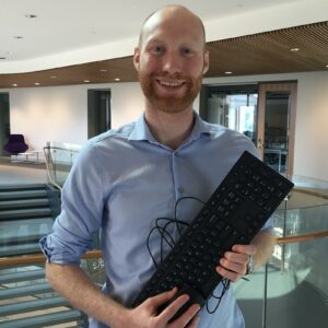 Justin Smith holds a computer keyboard.
